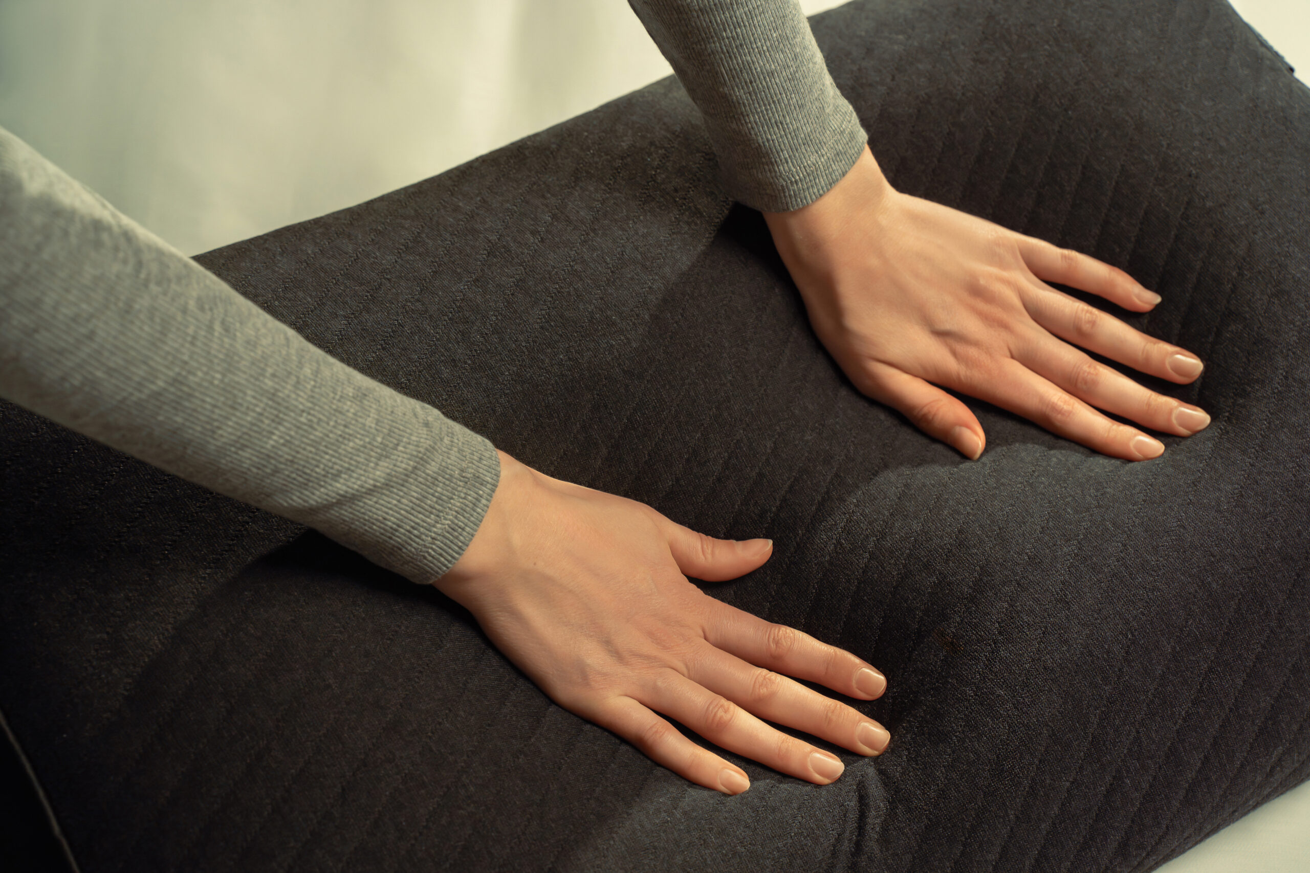 hands pressing on the eight sleep cover pillow